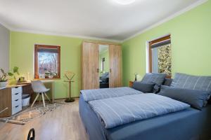 ein Schlafzimmer mit einem blauen Bett und grünen Wänden in der Unterkunft Spreequartier in Malschwitz