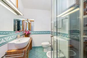a bathroom with a sink and a toilet and a glass shower at 1 Appartamento Lu Impostu in San Teodoro +16 photos