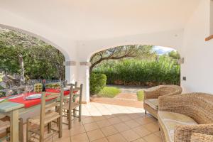 a patio with a table and chairs and an archway at 1 Appartamento Lu Impostu in San Teodoro