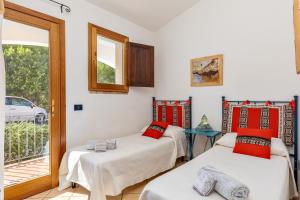 two beds in a room with a balcony at 1 Appartamento Lu Impostu in San Teodoro