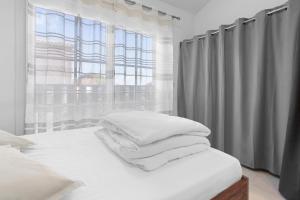 a bedroom with a bed with white pillows and a window at Studio 2 proche centre avec parking in Fréjus