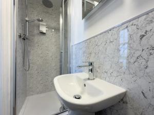 a white bathroom with a sink and a shower at The Esplanade Hotel by Compass Hospitality in Paignton +37 photos