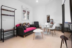 a living room with a couch and a table at Studio 2 proche centre avec parking in Fréjus