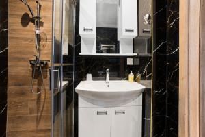 a bathroom with a white sink and a shower at Studio 2 proche centre avec parking in Fréjus +18 photos