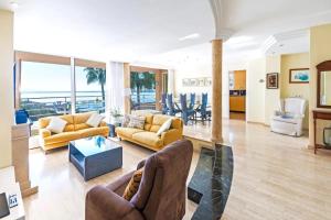 a living room with yellow furniture and a view of the ocean at Alcanada Paradise in Alcudia