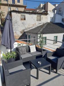 a patio with chairs and a table and an umbrella at D'ouro Relax - Douro Vinhateiro in Sanfins do Douro