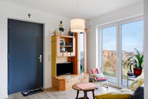a living room with a black door and a tv at Am Rothen Hang in Oberelsbach