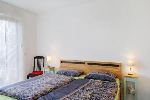 two beds in a bedroom with two lamps on tables at Am Rothen Hang in Oberelsbach
