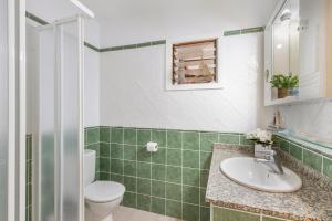 a bathroom with a sink and a toilet at Orion Beach in Puerto +21 photos