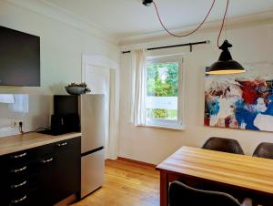 a kitchen with a refrigerator and a table and a window at Ferienwohnung Lichtenstein in Lichtenstein +17 photos