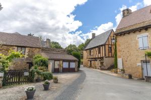 an empty street in a village with buildings at Maison familiale à Archignac in Archignac
