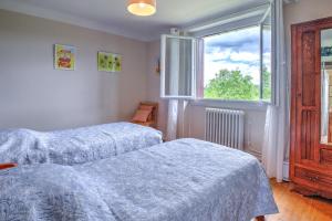 a bedroom with two beds and a window at Maison familiale à Archignac in Archignac