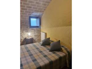 a bedroom with a bed with a plaid blanket at Mas Pareta - La Parra 1 in Fonolleras