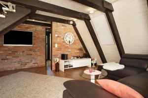 a living room with a clock on a brick wall at Ferienhaus Exquisit in Immenstaad am Bodensee