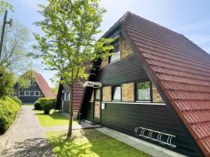 a black house with a red roof at Ferienhaus Exquisit in Immenstaad am Bodensee