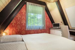 a bedroom with a white bed and a window at Ferienhaus Exquisit in Immenstaad am Bodensee