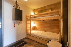 a bunk bed in a room with a tv and a bed at 2 alpes in Les Deux Alpes