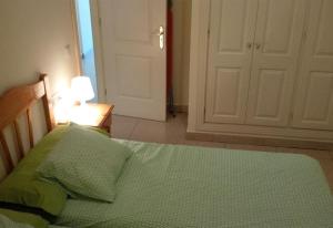a bedroom with a bed with green sheets and a door at Los Cristianos plaza property in Los Cristianos +21 photos