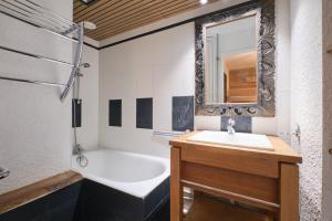 a bathroom with a sink and a tub and a mirror at 2 alpes in Les Deux Alpes +12 photos