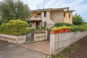a house with plants in front of a fence at La Casa nel Verde in Altopascio