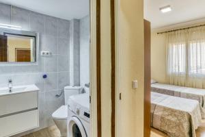 a bathroom with a toilet a sink and a washing machine at Apartamento la Siesta in L'Escala +17 photos