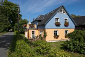 a blue and yellow house with flower boxes on the windows at Teichmühle - Vogtland Chalet in Bad Brambach