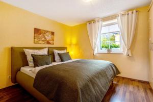 a bedroom with a large bed with a window at Teichmühle - Vogtland Chalet in Bad Brambach