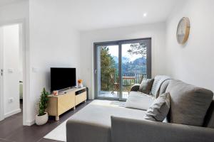 a living room with a couch and a tv at Gerês Hideaway in Vilar da Veiga