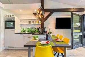 a kitchen with a dining table and yellow chairs at Feichten Glück 16 in Siegsdorf