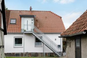 a white house with a staircase on it at Haus Kirchenblick in Kalkhorst