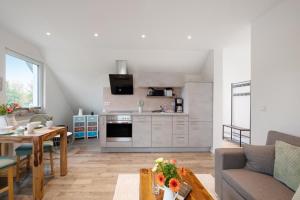 a kitchen and living room with a table and a couch at Haus Kirchenblick in Kalkhorst