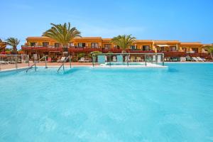 a large pool of blue water in front of a building at Surf Home Sea View in Costa de Antigua