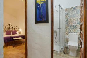 a bathroom with a shower and a toilet and a bed at Casa Mamayana in Telde +14 photos