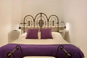 a bed with purple sheets and purple pillows at Casa Mamayana in Telde