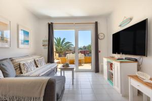 a living room with a couch and a flat screen tv at Surf Home Sea View in Costa de Antigua