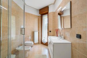 a bathroom with a toilet and a sink and a mirror at Casa Rosada Monza Autodromo in Nova Milanese +10 photos