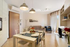 a kitchen and living room with a table and chairs at Casa Rosada Monza Autodromo in Nova Milanese