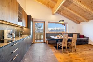a kitchen and dining room with a table and a couch at Ferienwohnung Gruberhof in Verano