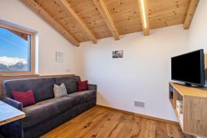 a living room with a couch and a flat screen tv at Ferienwohnung Gruberhof in Verano