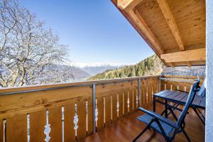 a rocking chair on a porch with a view of the mountains at Ferienwohnung Gruberhof in Verano