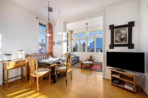 a dining room with a table and a television at Haus Übersee Wohnung Timbuktu in Travemünde