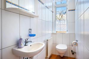 a white bathroom with a sink and a toilet at Haus Übersee Wohnung Timbuktu in Travemünde +19 photos