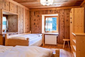 a bedroom with two beds and a window at Muncion Apparte in Pozza di Fassa