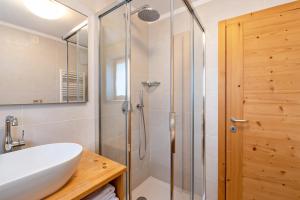 a bathroom with a shower and a white sink at Muncion Apparte in Pozza di Fassa +20 photos