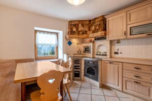 a kitchen with wooden cabinets and a wooden table at Muncion Apparte in Pozza di Fassa