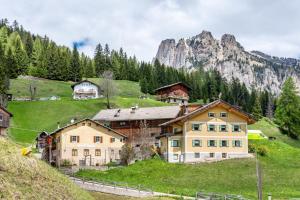 a house on a hill with mountains in the background at Muncion Apparte in Pozza di Fassa