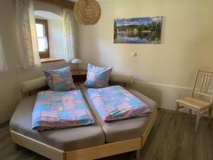 a small room with two beds and a chair at Haus Peschl Fewo 1 in Neureichenau