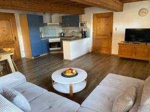 a living room with a couch and a table at Haus Peschl Fewo 1 in Neureichenau +7 photos