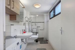 a white bathroom with a sink and a toilet at Apartment Alte Poststation in Wehr