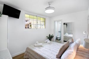a white bedroom with a bed and a window at Liomor Luxury in Caleta De Fuste +16 photos